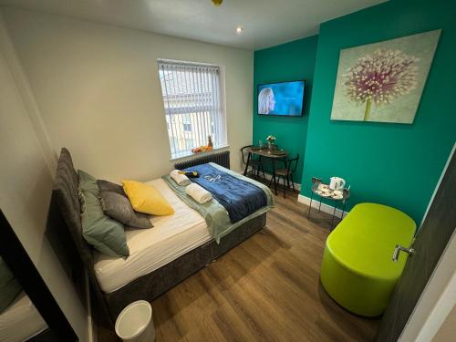 a bedroom with a bed and a green wall at Luxury 6-Bed House - 6 En Suite- Jaquzzi Baths - Private Parking - Sleeps 22- 2 Min M62 in Elland