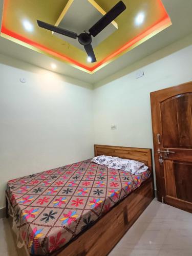 a bedroom with a bed and a ceiling fan at RS Homestay Puri in Puri