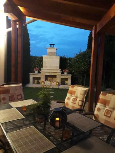 a patio with a cake and a monument in the background at Canadian style house with 3D effect pool in Vinosady