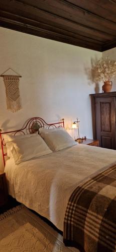 ein Schlafzimmer mit einem großen Bett mit einem hölzernen Kopfteil in der Unterkunft Casa Grande - Casas de Campo na Serra da Estrela in Paços da Serra