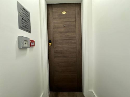 a hallway with a wooden door in a room at Luxury 6-Bed House - 6 En Suite- Jaquzzi Baths - Private Parking - Sleeps 22- 2 Min M62 in Elland
