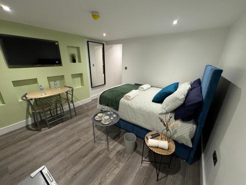 a bedroom with a bed and a table in it at Luxury 6-Bed House - 6 En Suite- Jaquzzi Baths - Private Parking - Sleeps 22- 2 Min M62 in Elland