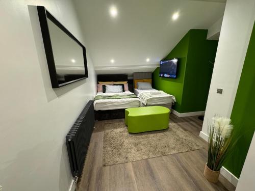 a room with two beds and a tv on the wall at Luxury 6-Bed House - 6 En Suite- Jaquzzi Baths - Private Parking - Sleeps 22- 2 Min M62 in Elland