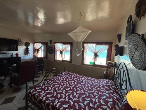 a bedroom with a bed and two windows at Maison Couleur Passion in Nianing