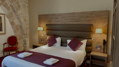a hotel room with a bed with two towels on it at L'Hostellerie du Château de Bricquebec in Bricquebec