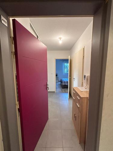 Cette chambre dispose d'une porte violette et d'une cuisine. dans l'établissement Appartement aucamville T2 avec jardin, à Aucamville
