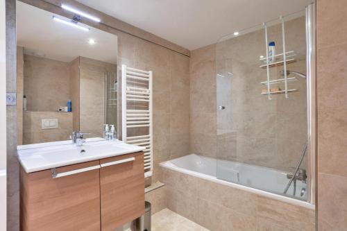 une salle de bain avec une baignoire, un lavabo et une douche dans l'établissement Résidence Le Chalet des Rennes - maeva Home - Appartement cosy 3 pièces 8 personnes - Exclusive - super Home MAE-6304, à Vars