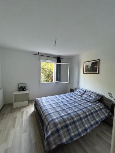 une chambre avec un lit et une fenêtre dans l'établissement Appartement aucamville T2 avec jardin, à Aucamville