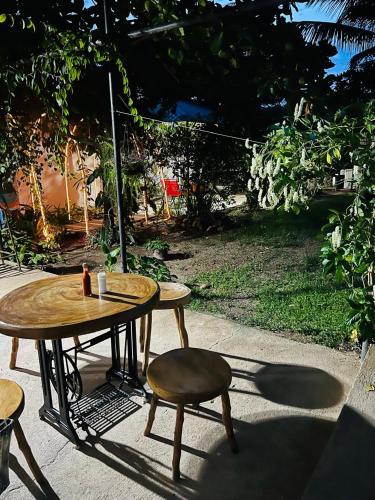 two tables and a stool and a table and a chair at Aparta Hotel Palmerola in Comayagua