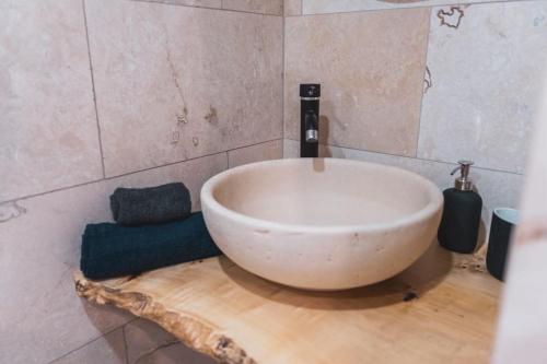 a bathroom with a large white bowl sink on a wooden floor at NORMALT- luxurious stay in Il-Furjana