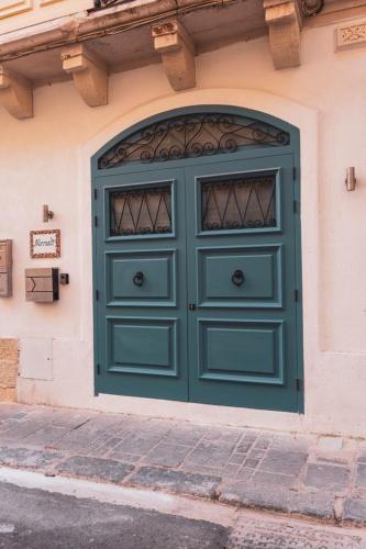 a green door on the side of a building at NORMALT- luxurious stay in Il-Furjana