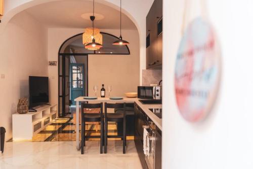 a kitchen with a table and chairs in a room at NORMALT- luxurious stay in Il-Furjana