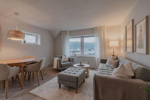 een woonkamer met een bank, stoelen en een tafel bij Apartment in Tromsø City Centre in Tromsø