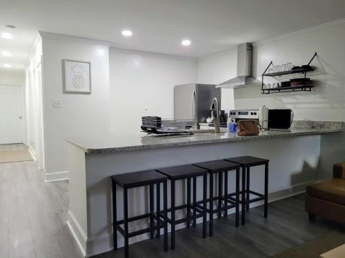 a kitchen with a counter and stools in a room at Renovated 2 Bed Walltown Home Walk To Duke! B in Durham