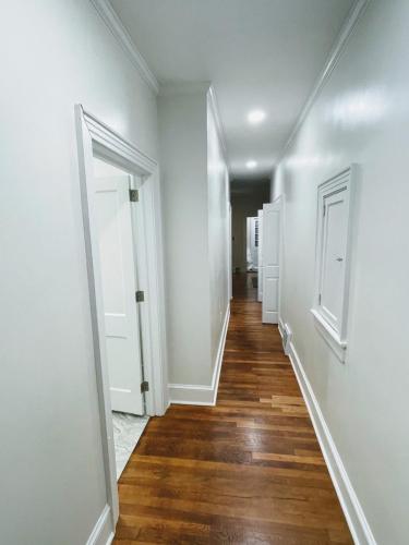 an empty hallway with white walls and wooden floors at Renovated 1 bedroom in Forest Hills - B in Durham