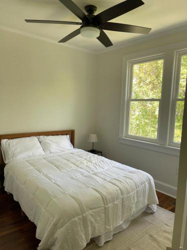 a bedroom with a white bed with a ceiling fan at Renovated 1 bedroom in Forest Hills - B in Durham