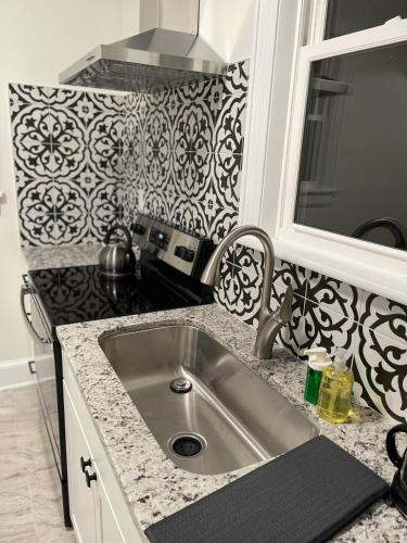 a kitchen counter with a sink and a mirror at Renovated 1 bedroom in Forest Hills - B in Durham