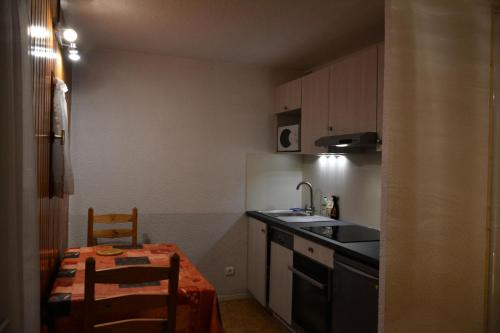 une petite cuisine avec une table et un évier dans l'établissement Résidence Les Bergers - 2 pièces cabine 4 personnes exposé Nord-Ouest MAE-8954, à Valloire