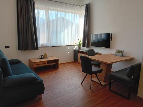 - un salon avec une table, un canapé et une télévision dans l'établissement Haus Eisenhut INKLUSIVE SuperSommerCard, à Fiss