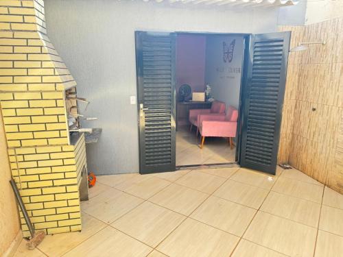 an open door to a room with a pink chair at SOBRADO COM 3 QUARToS in Barretos