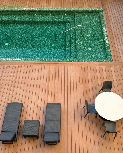 a pool with a table and chairs next to a swimming pool at Holiday Inn Navojoa by IHG in Navojoa