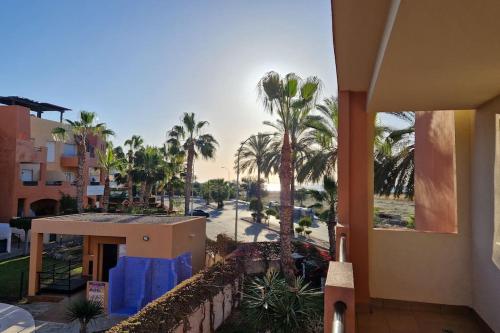 a view of a resort with palm trees and a street at Apartamento junto al mar in Vera