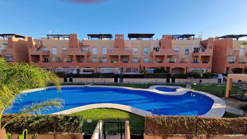 a large swimming pool in front of a large building at Apartamento junto al mar in Vera