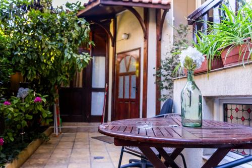 a wooden table with a vase of flowers on it at Family House Katerini in Nesebar
