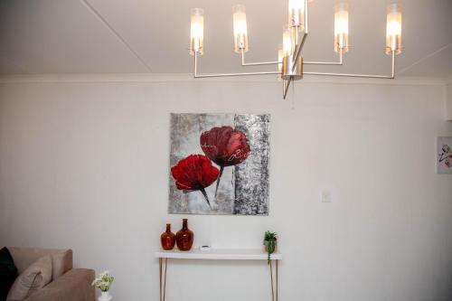 a living room with a painting of two red roses at Urugo in Randburg