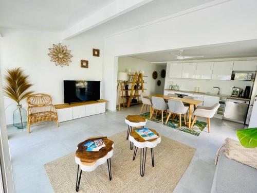 a living room with a table and chairs and a kitchen at Palm Beach House, Stunning 2 bedrooms beachfront, Nettle Bay Beach Club in Baie Nettle