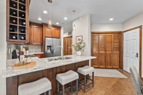 eine Küche mit Spüle und Theke mit Hockern in der Unterkunft 1BR Deer Valley Condo-On FREE Shuttle Line in Park City