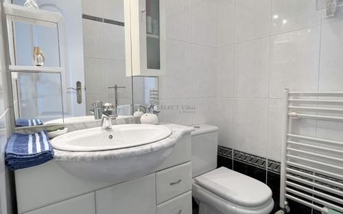 Un baño blanco con lavabo e inodoro. en Villa Cost-a Blanca, en Benissa