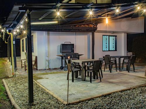 un patio con mesa y sillas por la noche en Hermosa finca con vista a la piedra y embalse de Guatapé, con jacuzzi y piscina, en Guatapé