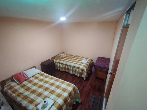 a small room with two beds in a room at Inti Ut'ha in Puno