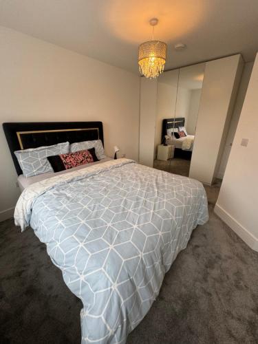 a bedroom with a large white bed and a chandelier at Foxburrow in Ballyclider