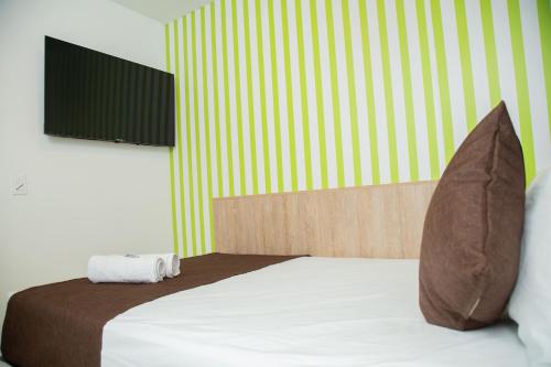 a bedroom with a bed with two pillows at Bajo la luna hotel in Medellín