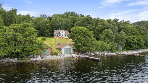 an island in the water with a house on it at Beautiful Beach line Cabin with sauna near Pulpit Rock in Forsand