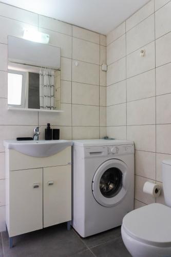 a bathroom with a washing machine and a sink at Spacious seaview apartment in Heraklion in Heraklio