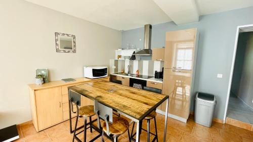 Il comprend une cuisine avec une table et des chaises en bois. dans l'établissement Maison de plain-pied avec un grand jardin, à Malicorne-sur-Sarthe