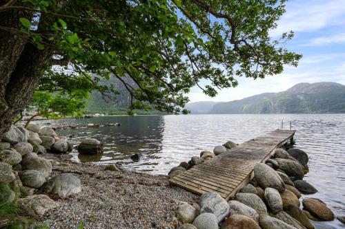 a wooden bridge over a body of water at Beautiful Beach line Cabin with sauna near Pulpit Rock in Forsand