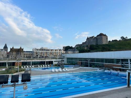 une grande piscine avec des chaises dans un bâtiment dans l'établissement Les Nids, à Dieppe