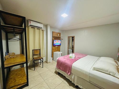 a bedroom with a bed and a desk and a television at Mansomar in Jericoacoara