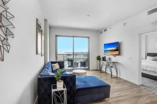 a living room with a blue couch and a bed at Urban Chic 1BR Downtown Tampa Pool & Balcony Views in Tampa