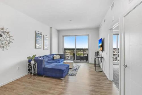 a living room with a blue couch and a window at Urban Chic 1BR Downtown Tampa Pool & Balcony Views in Tampa