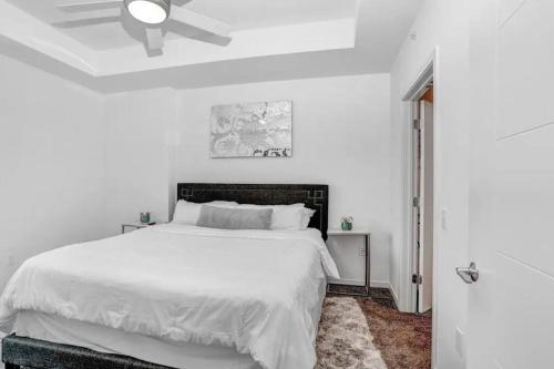 a white bedroom with a bed and a ceiling fan at Urban Chic 1BR Downtown Tampa Pool & Balcony Views in Tampa