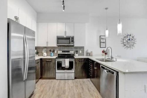 a kitchen with stainless steel appliances and wooden cabinets at Urban Chic 1BR Downtown Tampa Pool & Balcony Views in Tampa