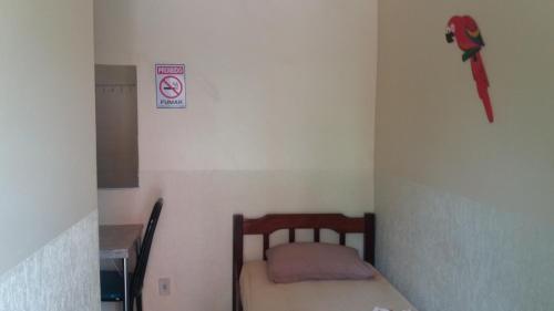 a small room with a small bed and a sign on the wall at Pousada Primavera in Bonito