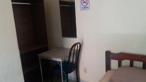 a small room with a small table and a bed at Pousada Primavera in Bonito