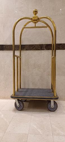 a gold luggage cart sitting in a room at الوان للشقق المخدومة in Khamis Mushayt