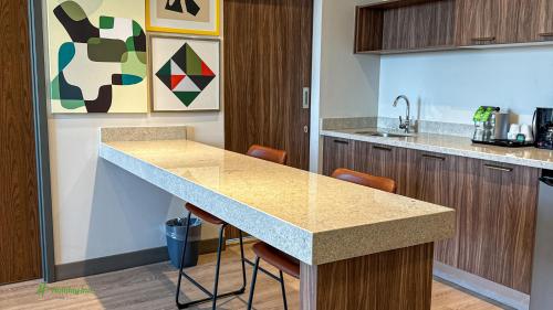 a kitchen with a counter and chairs in a room at Holiday Inn Navojoa by IHG in Navojoa